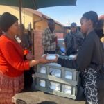 Volunteers handing out packed food to recipients