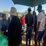 People gathered at an SA Imbokodo community food event
